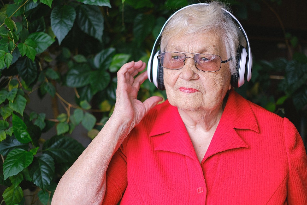 Mujer mayor escuchando música con cascos.