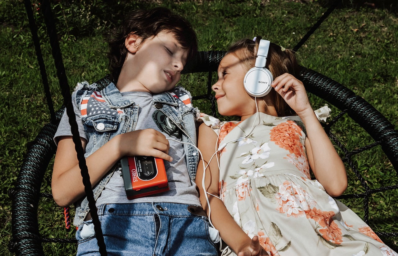 Dos niños tumbados escuchando música de un walkman